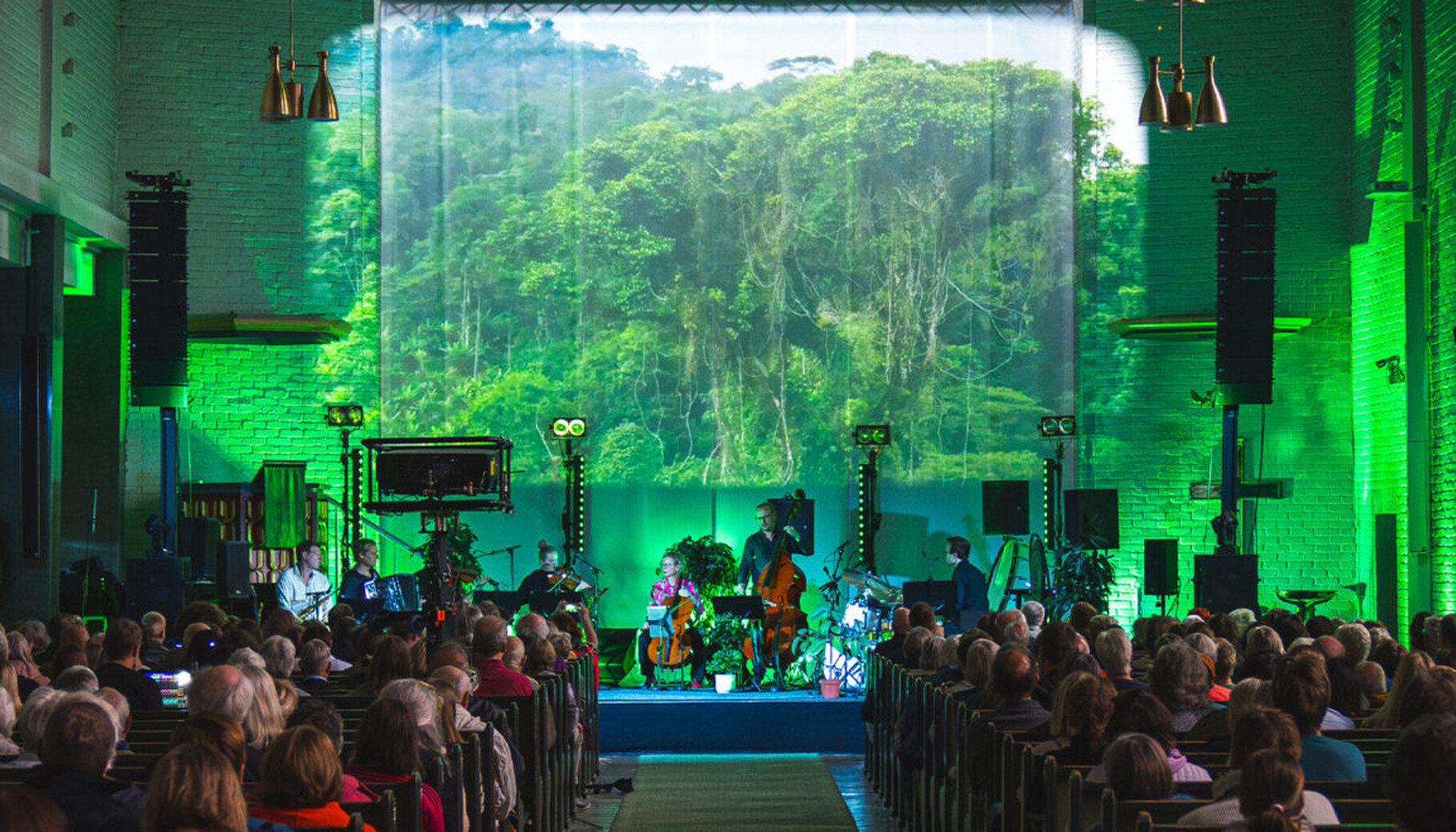 Som en del av kulissene projiseres bilder av regnskog, insekter og dyr på bakteppet. Foto: Istad Kraft Som en del av kulissene projiseres bilder av regnskog, insekter og dyr på bakteppet. Foto: Istad Kraft